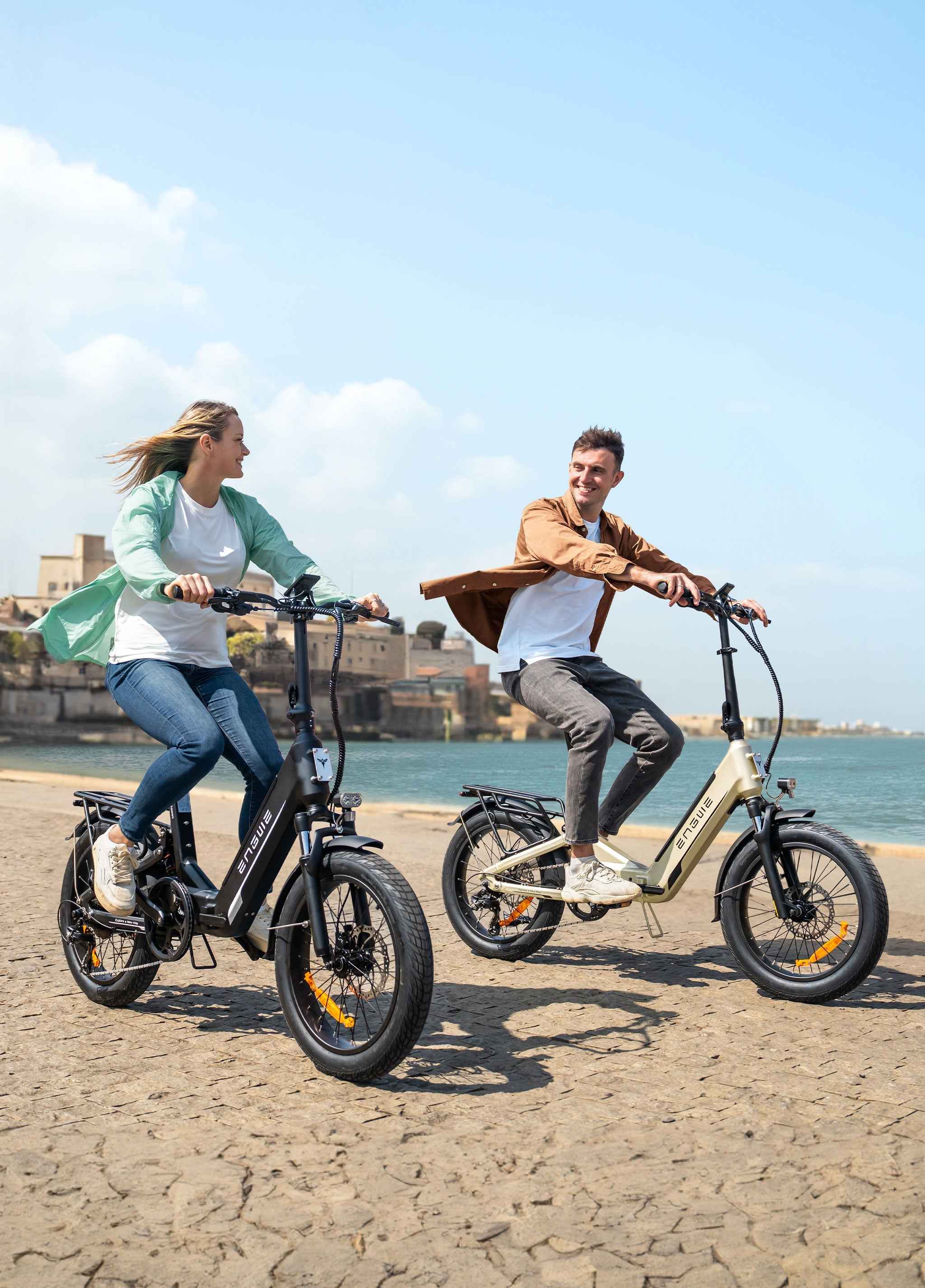Two riders enjoying the Engwe electric bicycle at a scenic coastal location