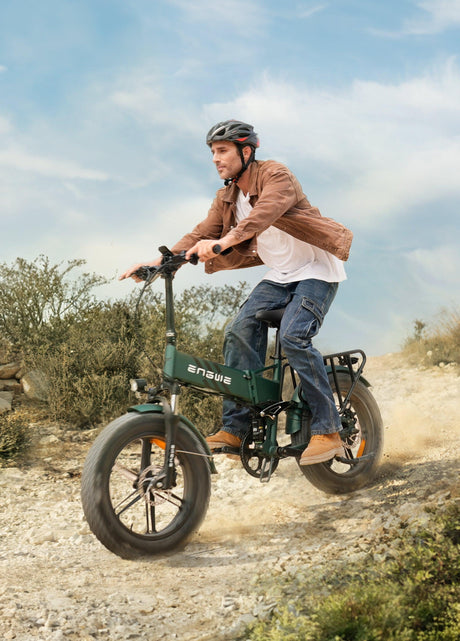 Man riding an ENGWE Engine Pro 2.0 electric bike on a rocky outdoor trail wearing helmet and casual clothes